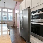 Services Spacious modern kitchen featuring stainless steel appliances and large windows with ample natural light.